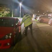 A Welwyn Hatfield Neighbourhood Policing Team officer trying car door handles in Panshanger