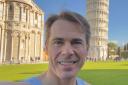 Russell Morris of Garden City Runners in front of the Leaning Tour of Pisa, the finish of the Pisa Marathon.