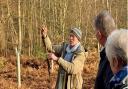 Jeremy Chase, woodland owner, showing volunteers the different types of trees.