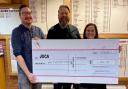 Justin Burgess of JOCA (middle) receives a cheque flanked by Alex Vooght and Rachel Elliott. Picture: WELWYN RUGBY