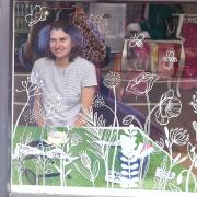 Ukrainian artist Hanna looking through the window she decorated at SuSu