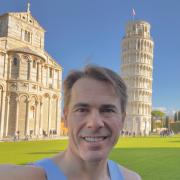 Russell Morris of Garden City Runners in front of the Leaning Tour of Pisa, the finish of the Pisa Marathon.