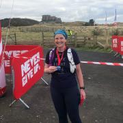 Kath Evans of Garden City Runners in front of Bamburgh Castle in Northumberland. Picture: GCR